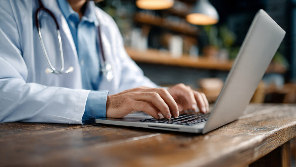 por favor crie um medico digitando em um laptop co